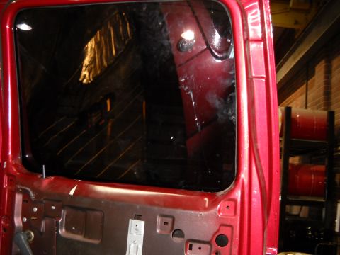1993 Ford C-150 (Centurion Conversions) - Interior view of a red truck door, showing the window frame and partially visible interior.