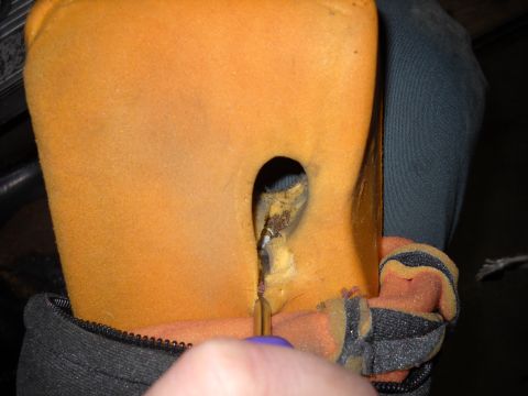 1993 Ford C-150 (Centurion Conversions) - A tool is used to probe a hole in the foam of a car seat, revealing damaged stuffing.