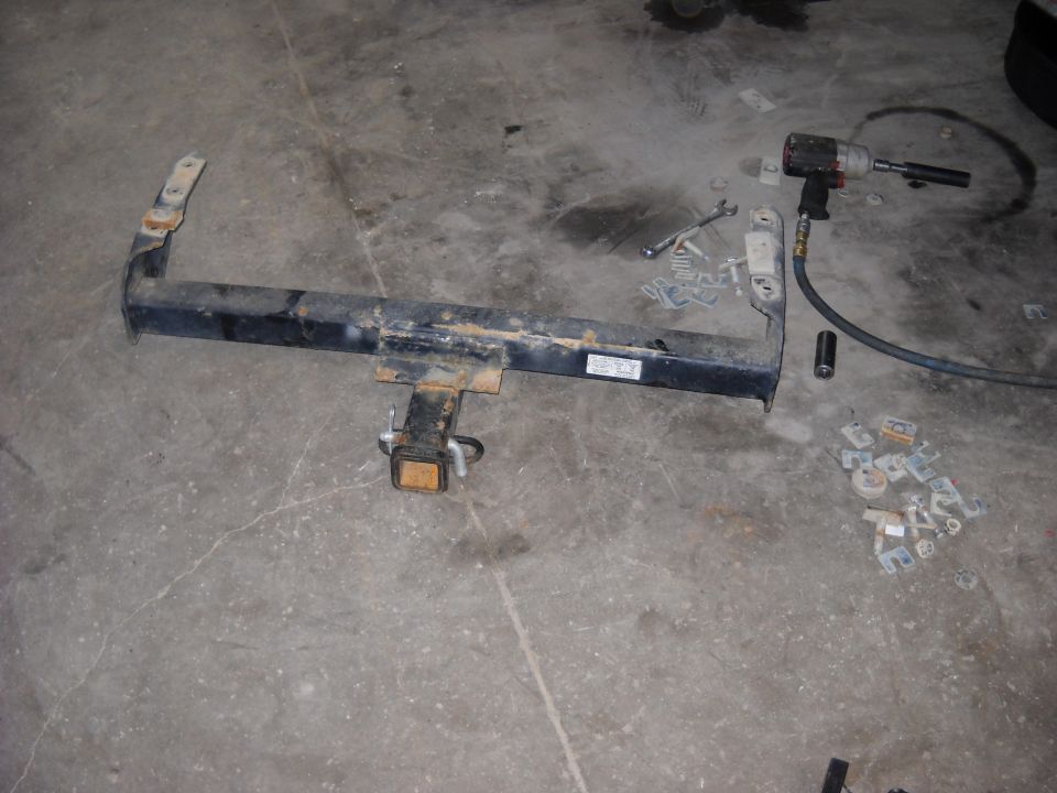 Trailer hitch with mounting hardware and impact wrench on concrete floor