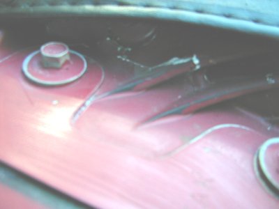 1997 Ford Taurus - Detail of a component within a vehicle's engine bay, showing fasteners and plastic trim.