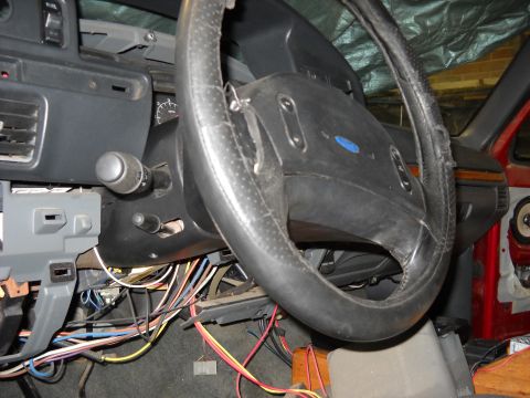 1993 Ford C-150 (Centurion Conversions) - The interior of a vehicle shows a steering column with many wires exposed beneath the dashboard.