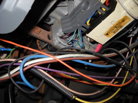 1993 Ford C-150 (Centurion Conversions) - A complex network of wires and connectors is visible in this close-up of a vehicle's steering column wiring harness.