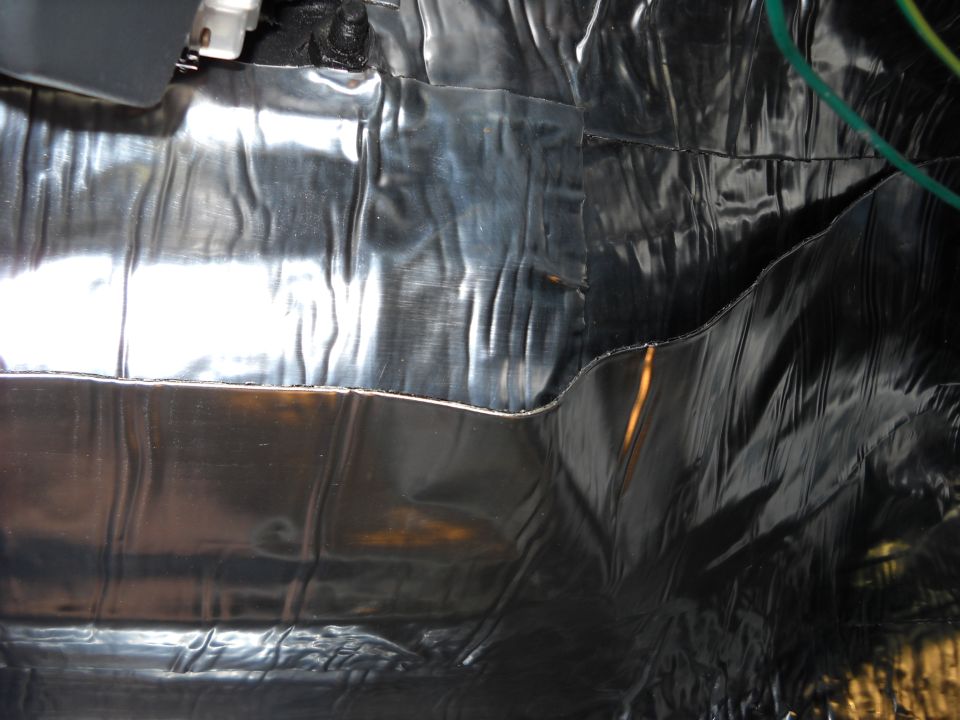 Close-up of shiny silver and black insulation material covering the interior of a vehicle