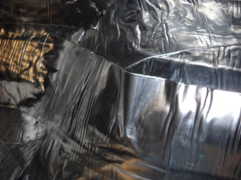 1993 Ford C-150 (Centurion Conversions) - Close-up of the wrinkled black vinyl interior upholstery, showing the texture and reflections.