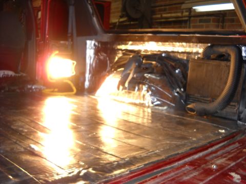 1993 Ford C-150 (Centurion Conversions) - The interior of a vehicle is being worked on, showing exposed insulation and a wooden floor.