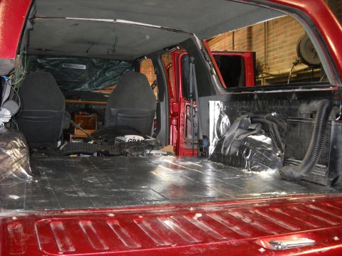 1993 Ford C-150 (Centurion Conversions) - The interior of a red truck shows exposed insulation and a bare floor, with seats removed for modification.