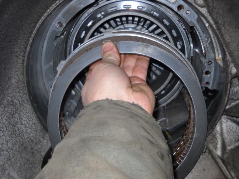 1993 Ford C-150 (Centurion Conversions) - Close-up of a transmission component being handled during a rebuild.
