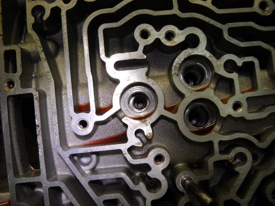 Close-up of an automatic transmission valve body with its intricate channels and ports