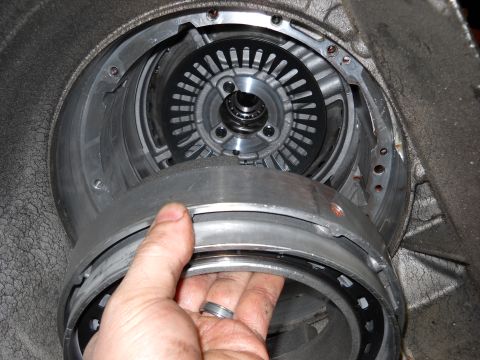 1993 Ford C-150 (Centurion Conversions) - Close-up view of a transmission component, possibly part of an E4OD rebuild, with a hand holding a section of the assembly.