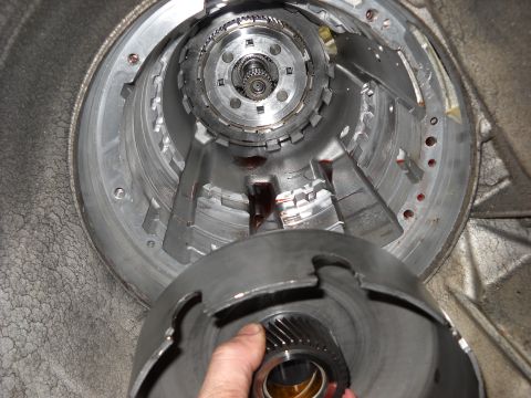 1993 Ford C-150 (Centurion Conversions) - Close-up view of a transmission part being held by a hand, with internal gears visible.