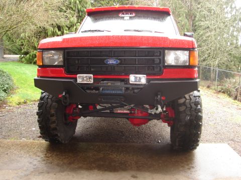 1989 Ford Bronco - Front view of a red Ford truck, likely from the late 1980s, equipped with a heavy-duty bumper and winch.