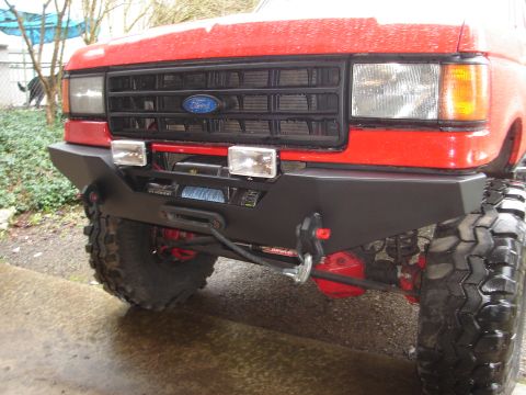 1989 Ford Bronco - Front view of a red 1989 Ford Bronco an aftermarket bumper with a winch and tow hook.