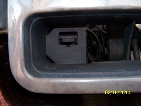 1989 Ford Bronco - Detail of a vehicle bumper opening, showing a black plastic component within.