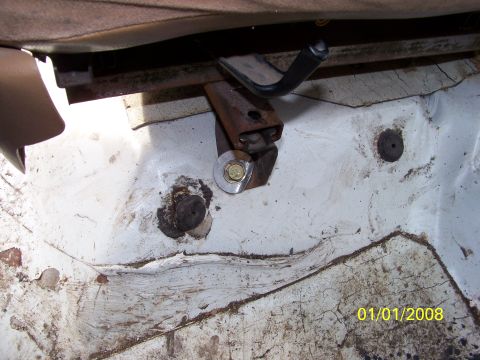 1989 Ford Bronco - Seat mounting bracket and bolt detail, likely from an older vehicle's interior.