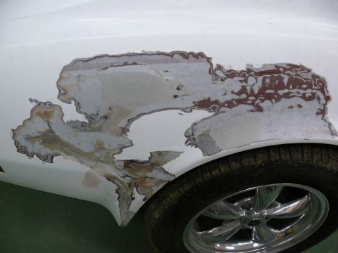 1976 Chevrolet Corvette - The bodywork on this vehicle shows significant damage and rust, with paint and filler flaking away.