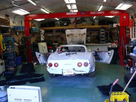 1976 Chevrolet Corvette - This 1976 Chevrolet Corvette is in a garage with its doors and hood open, appearing to be under repair.