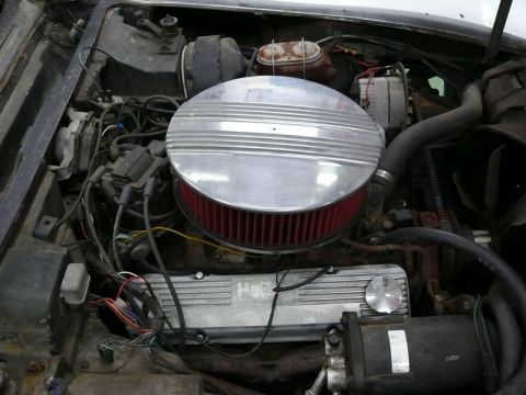1976 Chevrolet Corvette - The engine bay of a 1976 Chevrolet Corvette shows its V8 engine with custom chrome and aluminum accents.