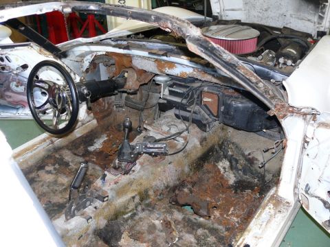 1976 Chevrolet Corvette - The interior of a 1976 Chevrolet Corvette shows significant rust damage throughout the cabin.