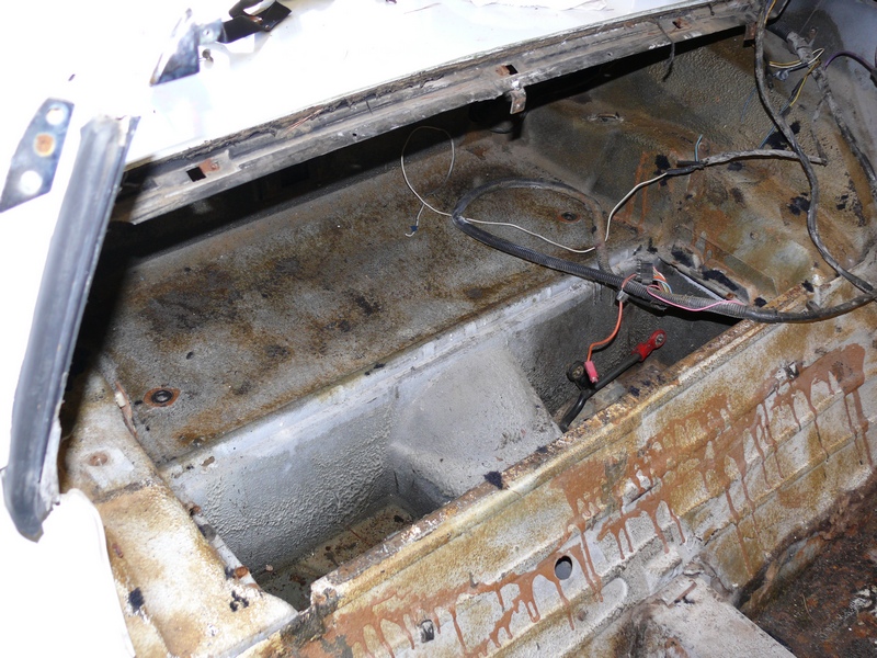 1976 Chevrolet Corvette interior rear cargo area with rust and wiring