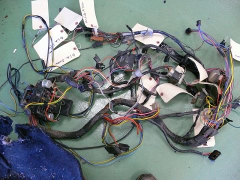 1976 Chevrolet Corvette - A complex vehicle wiring harness is laid out on a green surface, with several white tags attached.