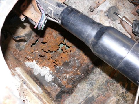 1976 Chevrolet Corvette - The floor pan of the vehicle shows significant rust damage and deterioration.