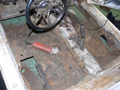 1976 Chevrolet Corvette - The interior floor of a car is heavily rusted and shows signs of repair work with an angle grinder.