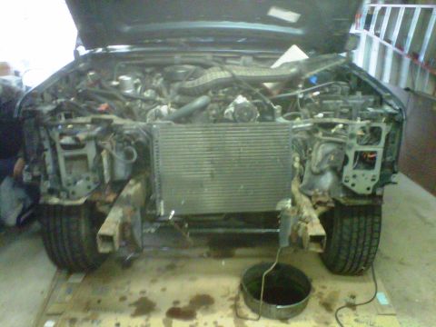 1996 Ford Bronco - Front view of a 1996 Ford Bronco with the hood open, showing the engine and disassembled front end.