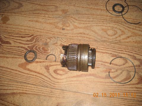 1982 Ford Bronco - A disassembled transmission part, likely a gear or clutch component, is shown with several snap rings on a wooden surface. The image includ…