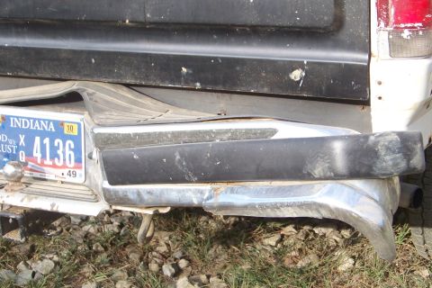 1989 Ford Bronco - The rear of a truck shows a damaged bumper and an Indiana license plate.