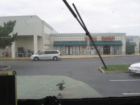 1985 Chevrolet Blazer - A white minivan is parked in front of a strip mall with a Grand Buffet restaurant visible.