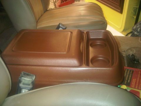 1978 Ford Bronco - Interior shot of a vehicle's center console with cup holders and storage compartment.