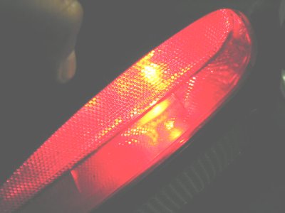 1997 Ford Taurus - Close-up of a red taillight with illuminated sections, showing a textured surface.