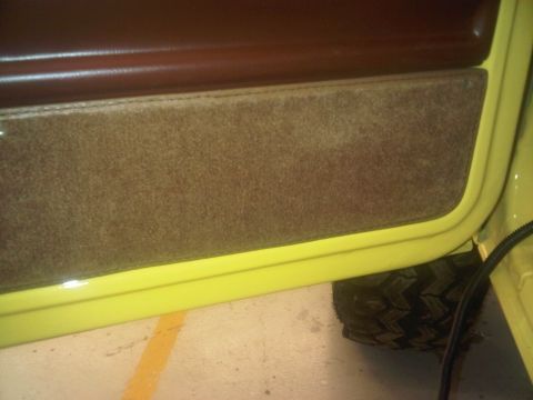 1978 Ford Bronco - Close-up of a vehicle's interior door panel and a tire, with a watermark at the bottom.