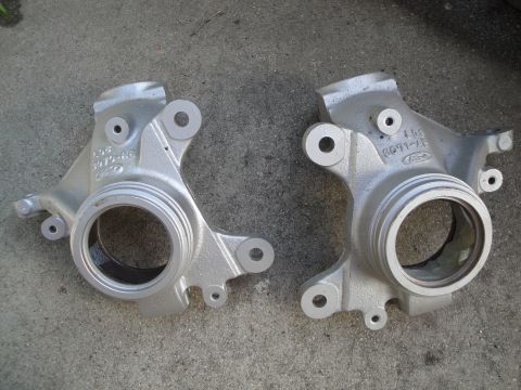 1993 Ford Taurus - Pair of Ford steering knuckles shown on a concrete surface.