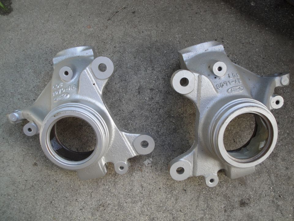 Two silver Ford steering knuckles with part numbers visible