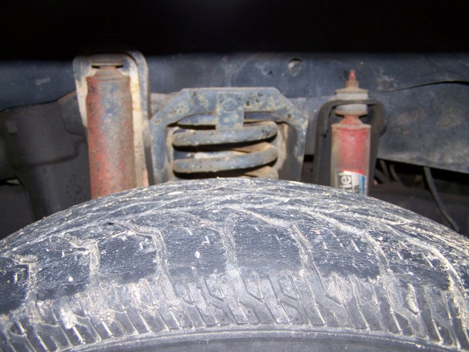 Tire and rusty rear suspension components including shock absorber and coil spring