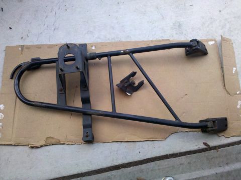 1995 Ford Bronco - Spare tire carrier frame for a vehicle, shown disassembled on cardboard.