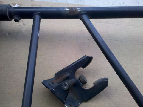 1995 Ford Bronco - A black metal frame section and bracket are shown, with visible rust on the frame.