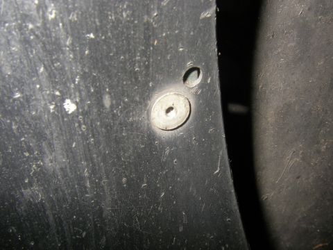 1990 Ford Bronco - Close-up of a fender flare attachment point, revealing wear and tear on the plastic component.