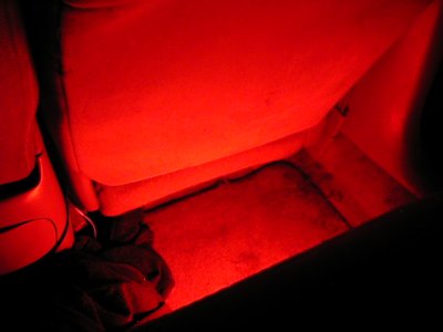 1997 Ford Taurus - The interior of a car is illuminated with red lighting, highlighting the floor and seats.
