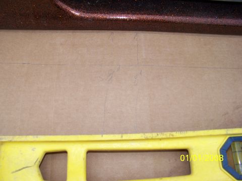 1989 Ford Bronco - Cardboard with measurements and a level are placed below a vehicle's body panel.