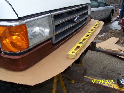 1989 Ford Bronco - A yellow level is placed on cardboard in front of a Ford truck's grille, with a date stamp of 01/01/2008.