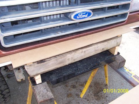 1989 Ford Bronco - Front view of a 1989 Ford Bronco's grille and bumper support, elevated on sawhorses.