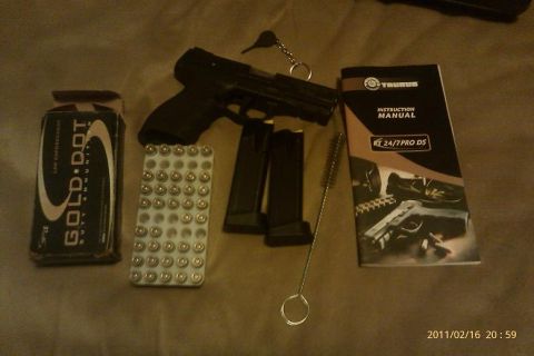 2000 Mercury Grand Marquis - A pistol, ammunition, and instruction manual are laid out on a textured surface.