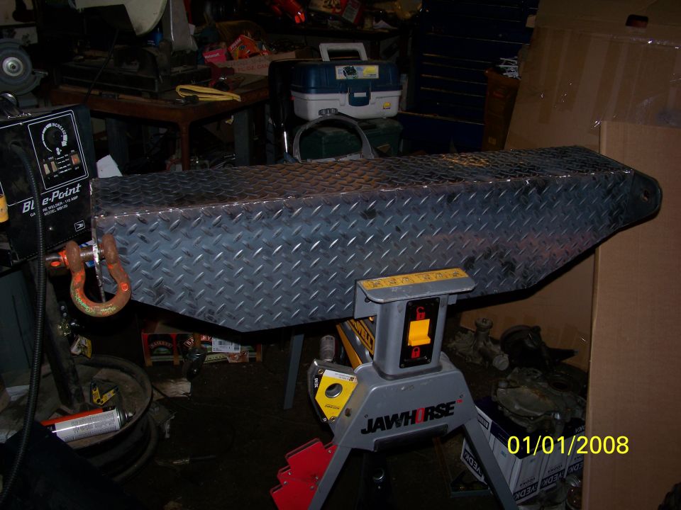 Diamond plate toolbox on a JAWHORSE stand, with a welding machine to the left