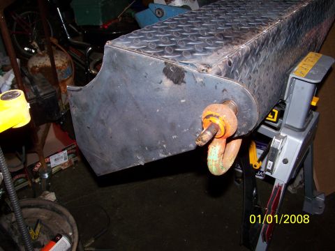 1989 Ford Bronco - A close-up view of a metal tow hitch assembly with a shackle, supported by a stand in a workshop setting.