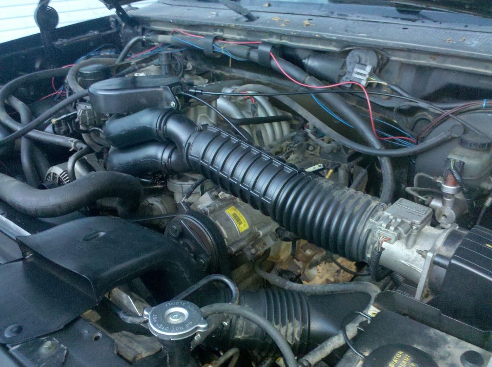 Engine bay with air intake hose, hoses, and wiring visible