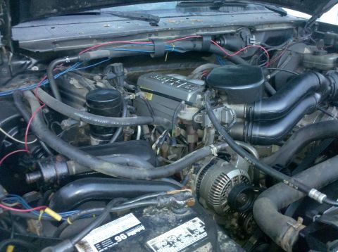 1995 Ford Bronco - The engine bay of a vehicle, showing various components and wiring.