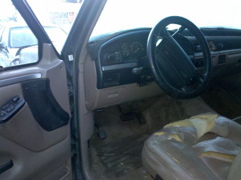1995 Ford Bronco - The interior of a 1995 Ford Bronco shows a worn driver's seat and dashboard.