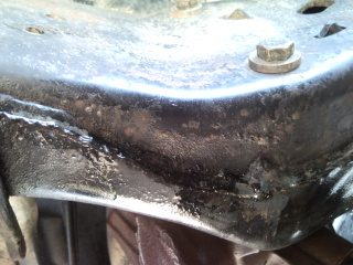 1985 Ford Bronco - Close-up of a vehicle's frame, showing a bolt and a watermark.